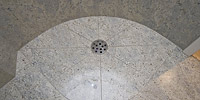 Dusche aus Kashmir White, der Abfluss im Boden.