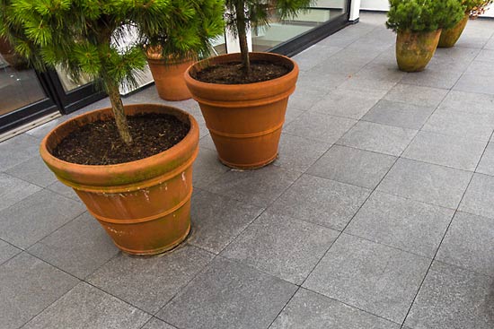 Black Pearl als großformatige Bodenplatten. Der Bodenbelag hat das Großformat 80 x 80 x 3 cm. Dieses Format wurde bis auf einige Ausnahmen im gesamten belegten Gartenbereich gewählt.