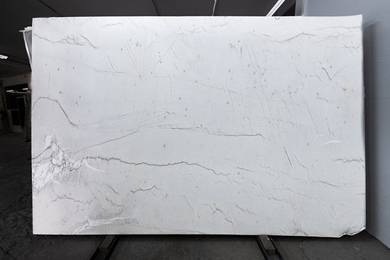 Calacatta Brasil, satiniert. Diese helle und kühle Natursteintafel erinnert an feine asiatische Landschaftszeichungen mit Tinte. Mit seinem hellen Grundton und den feinen dunklen Adern, gepaart mit weißen lebendigen Flächen, hat dieser Stein eine beeindruckend leichte optische Wirkung.
