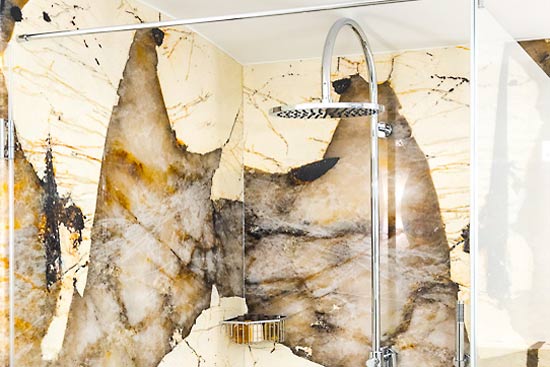 Badezimmer mit Dusche und WC in einem Spa-Bereich mit verschiedenen Natursteinen.