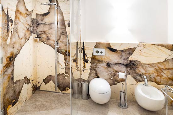 Badezimmer mit Dusche und WC in einem Spa-Bereich mit verschiedenen Natursteinen.